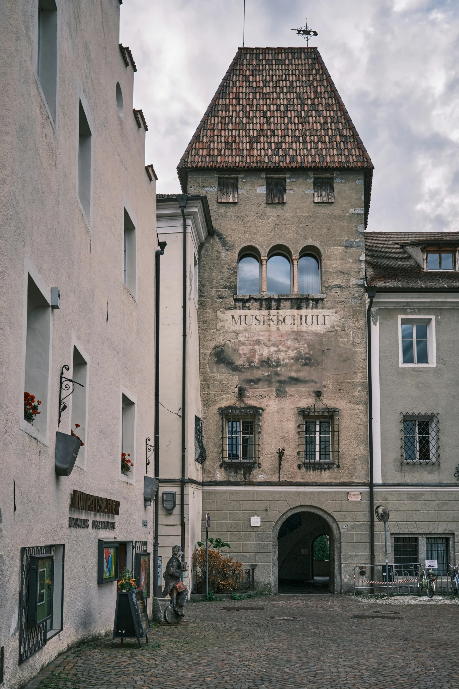 two buildings on a cobblestone road side by side