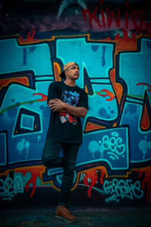 man with hand on chest standing against graffiti covered wall