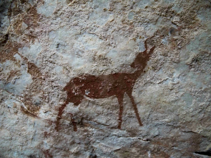 cave painting showing a deer and a calf running up the side