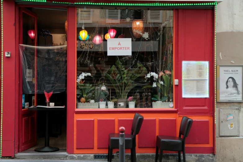 the front entrance to a colorful shop with some chairs outside