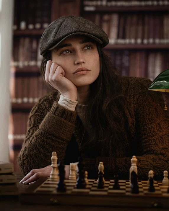 a woman with a hat sitting at a chess board