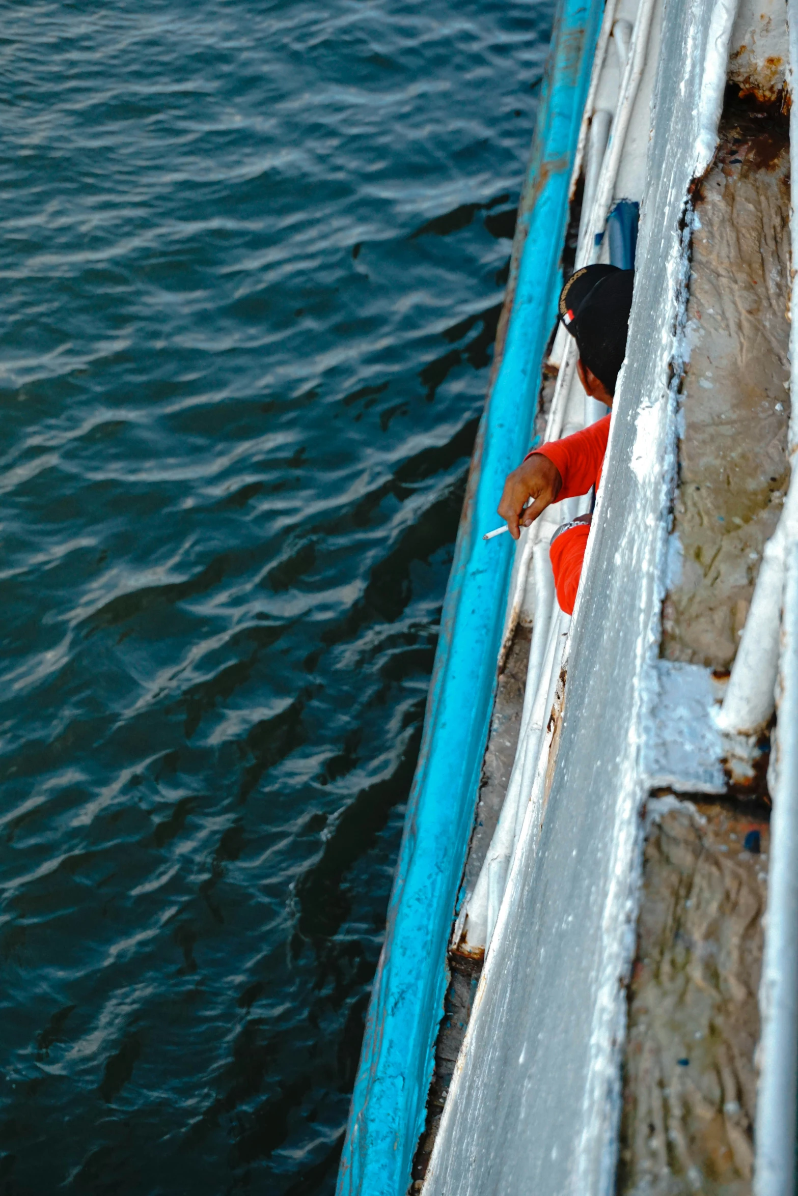 the person in the black hat is looking out of the boat