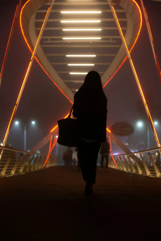 a person with a bag walking towards a large tower