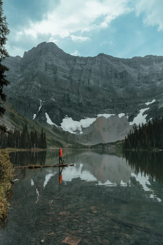 a lone person is standing in the calm waters