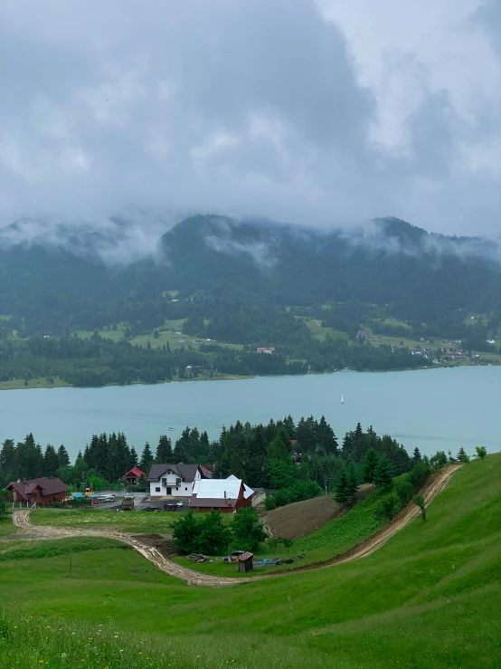 landscape in front of mountains with a body of water, farms and houses on the other side