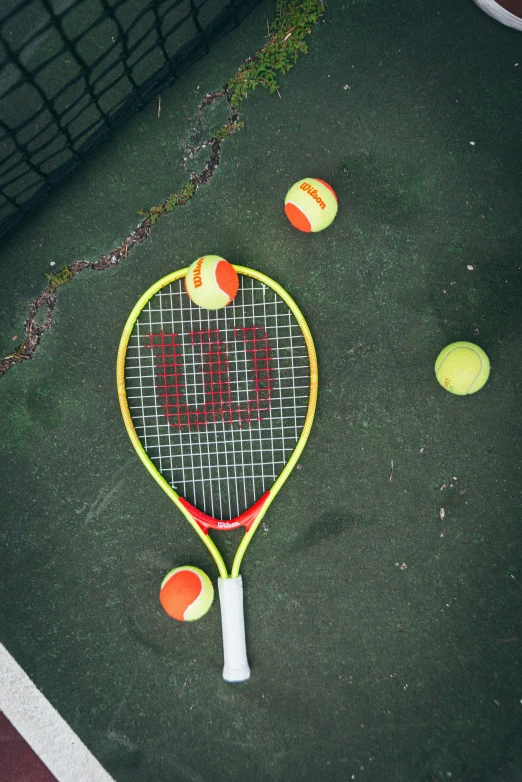 the top half of a yellow and black tennis racket on the ground