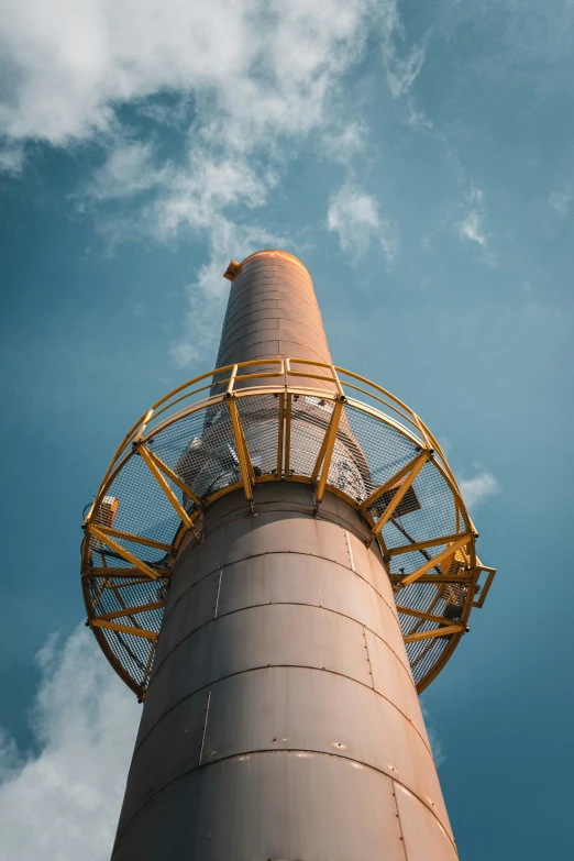 the top part of a tower under a partly cloudy blue sky