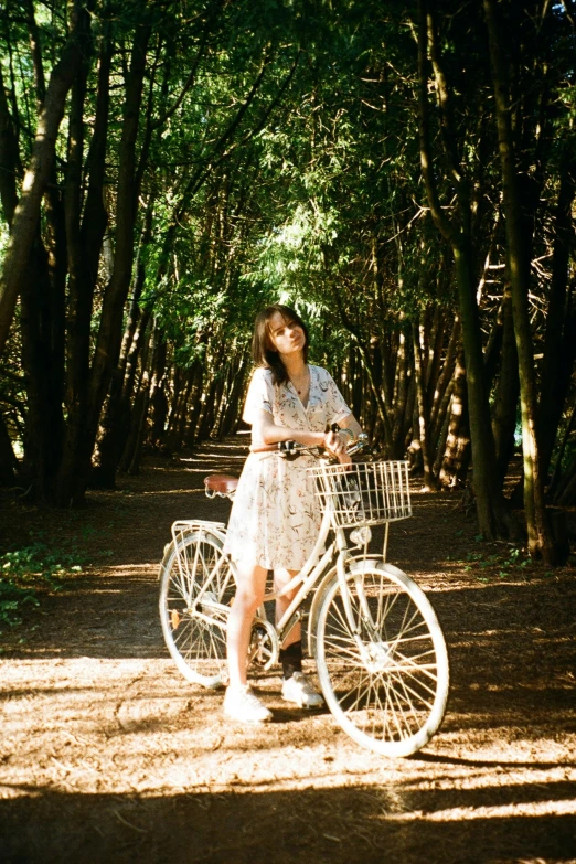 a young woman riding on the back of a bike through a forest