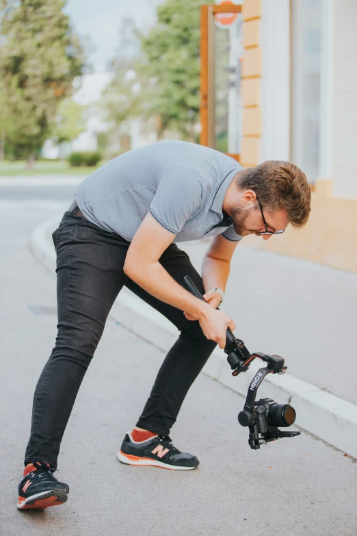 a man in sunglasses kneels next to a bike