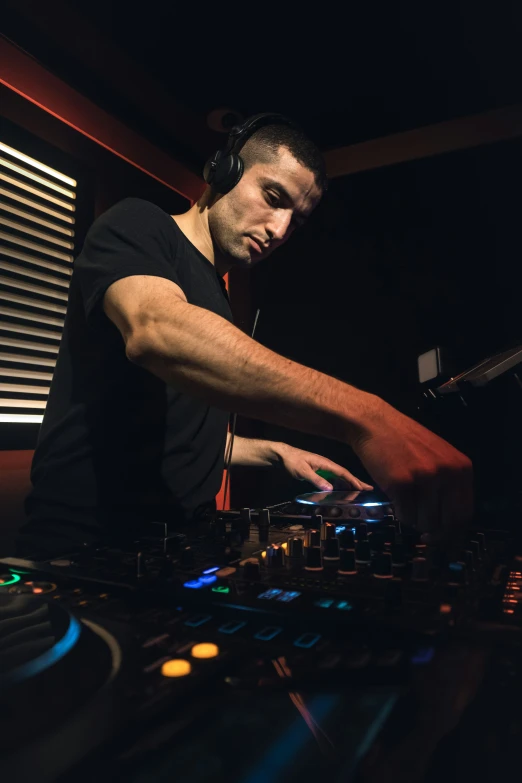 a dj in headphones mixing in front of a stage