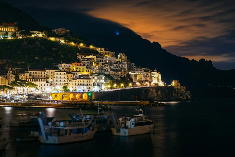 a city at night and many boats are docked in the water