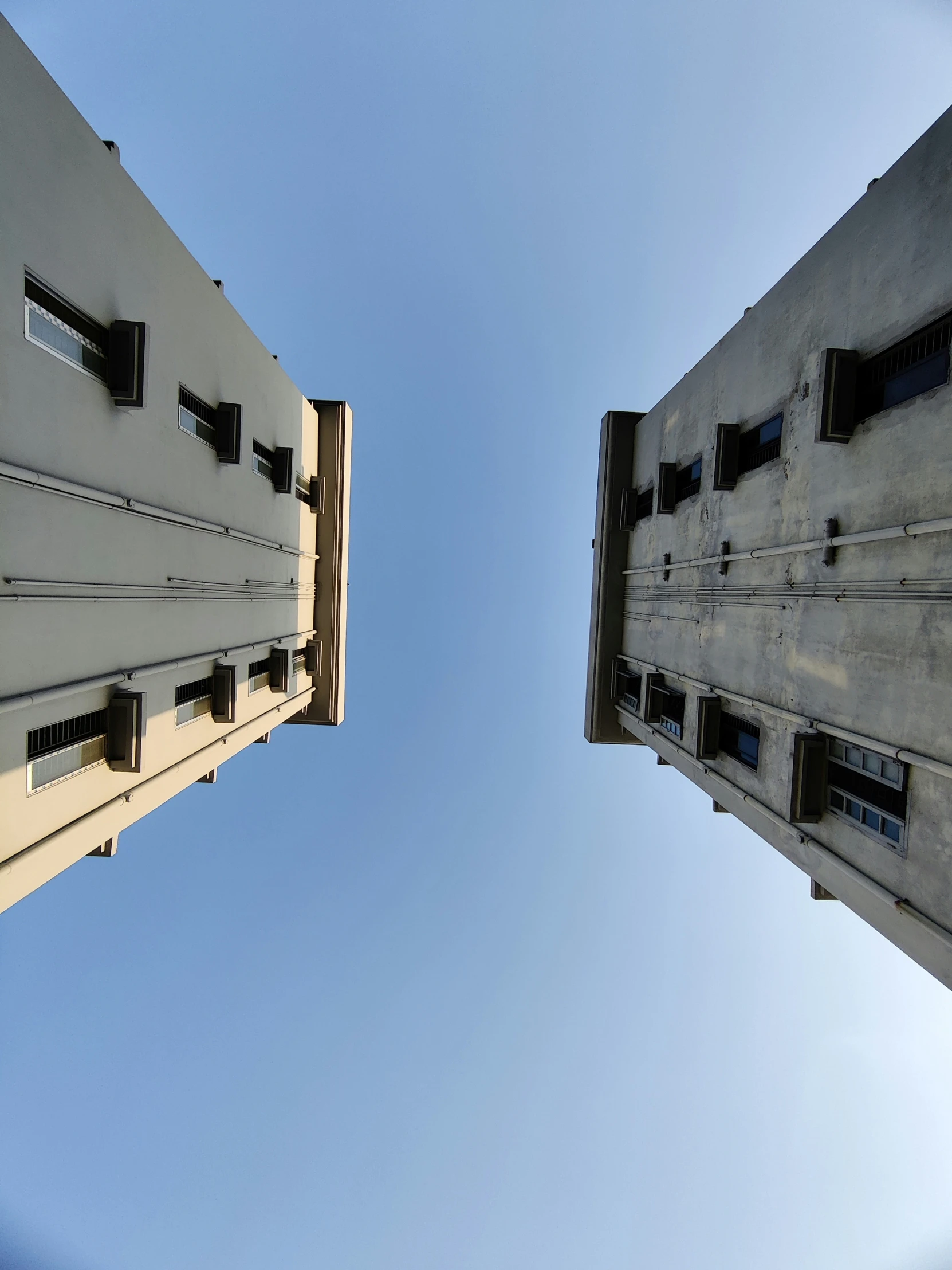 a couple of buildings with windows looking upward