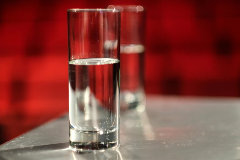 two s glasses on table with light reflecting on the surface