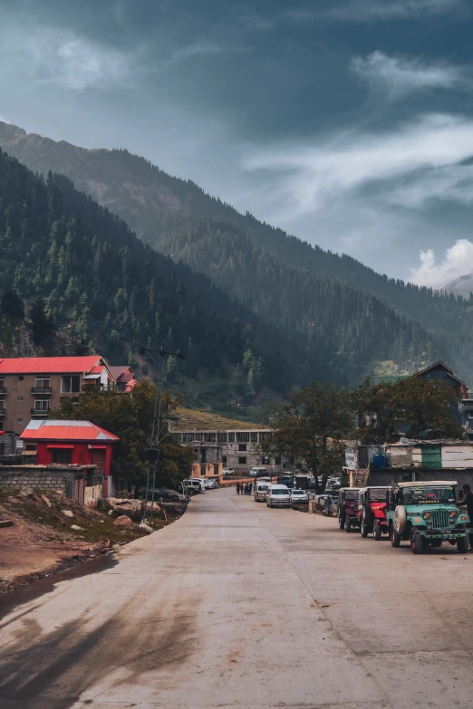 a rural street with many cars parked on it