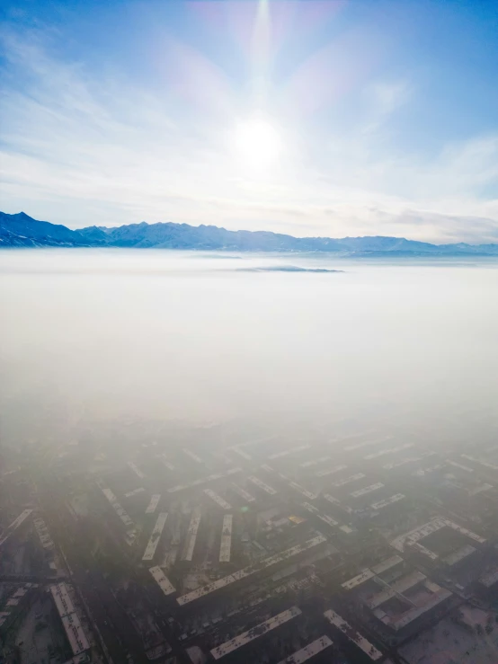 fog covers the surface of a vast landscape