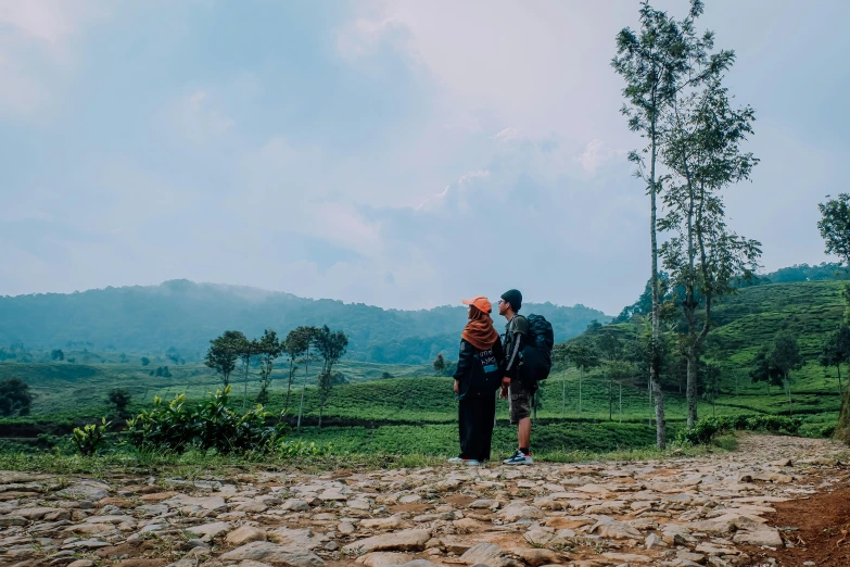 two men on a grassy field are holding an orange scarf