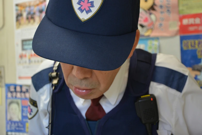 man in uniform examining device while wearing hat