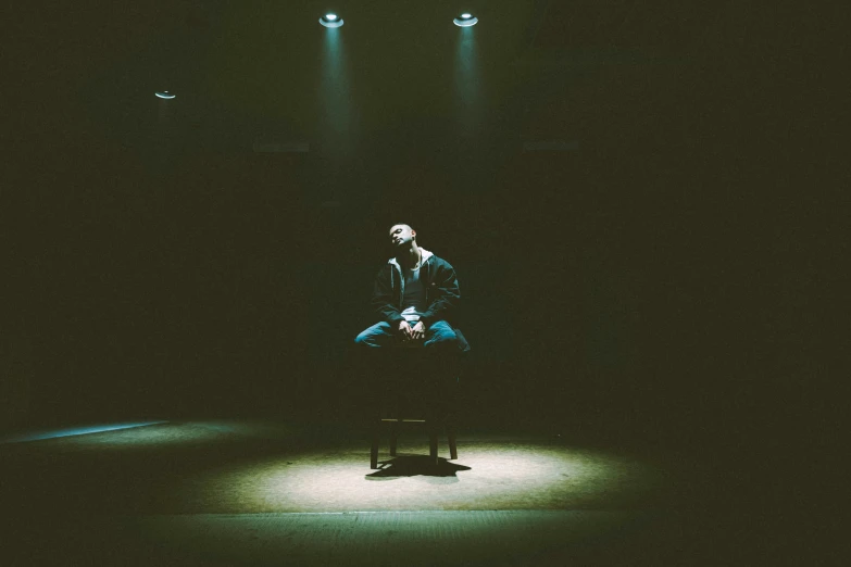 two men stand in the dark with spotlights