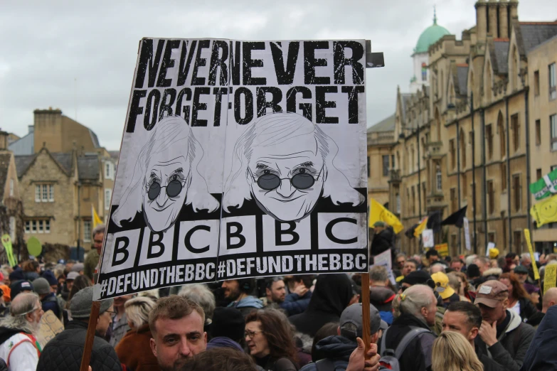 a large group of people holding signs with faces