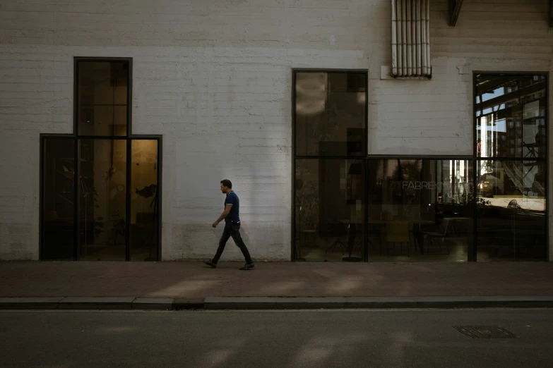a person walking by some big buildings near the street
