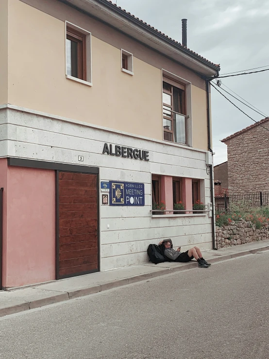 a man laying on the sidewalk in front of a building