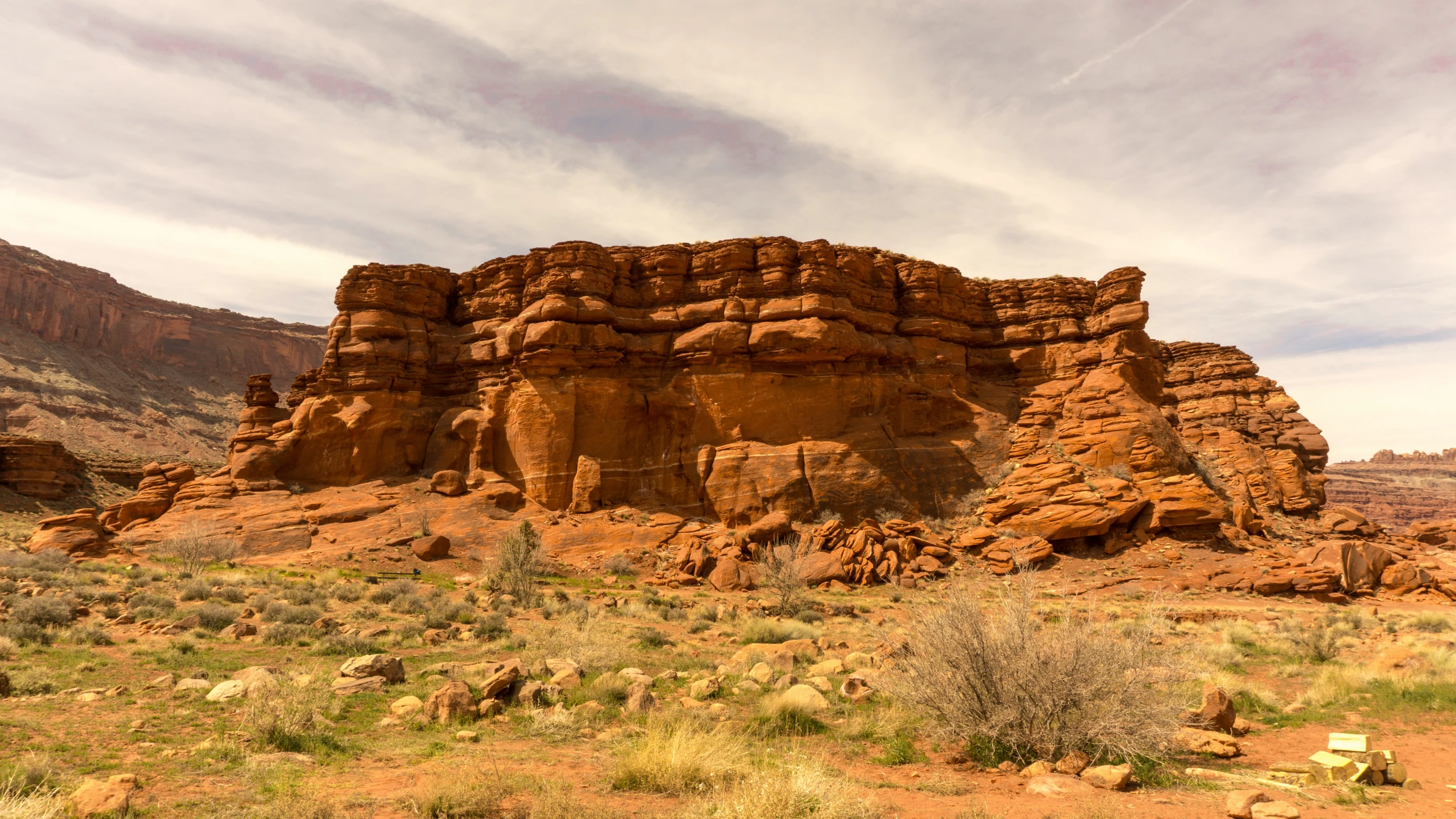 a large rock outcropping sitting in a desert field