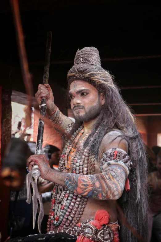 a man with long hair holding a sword in his right hand