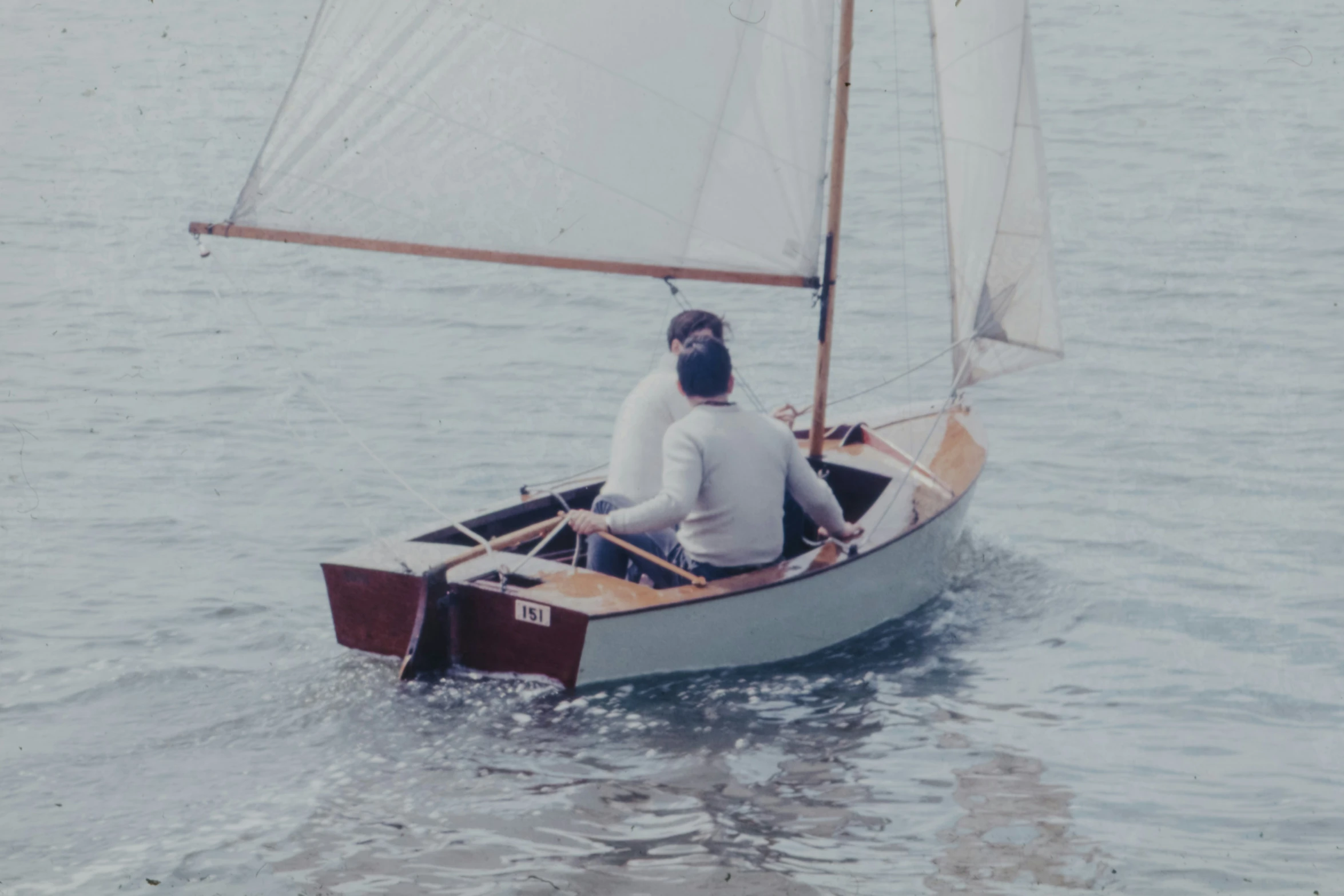 a man that is sitting in a sailboat