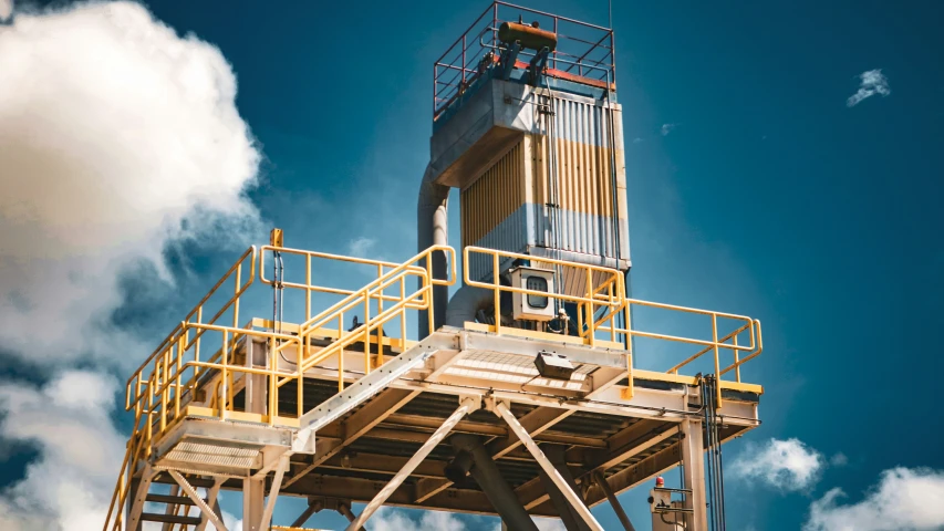 a tower with metal stairs and railings near clouds