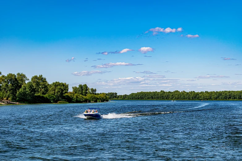 water skier with boat sailing by the shore