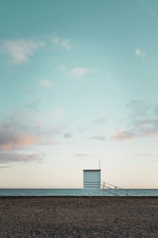 a life guard box on the beach near the water