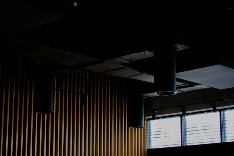 two windows inside of a building, a wood fence and a metal lamp on the ceiling