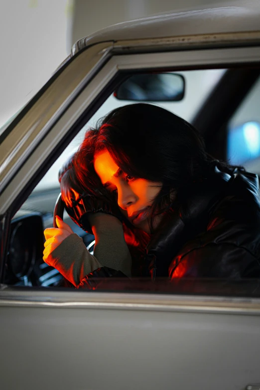a woman sitting in the car while talking on her cellphone