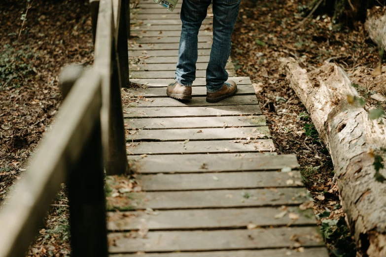 a person with their feet on a bridge