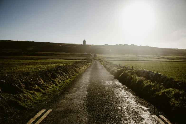 a long paved road leading to the horizon in an open field