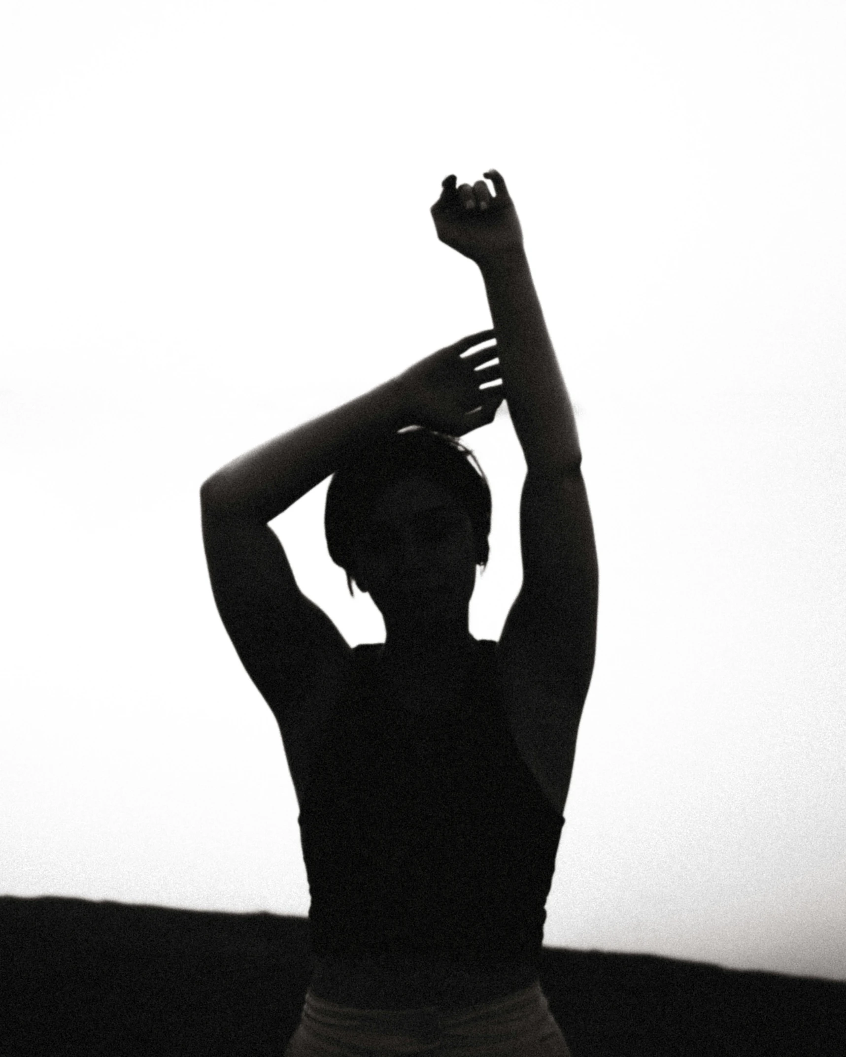 black and white silhouette of woman holding her arms up