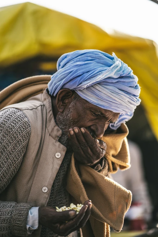 a man with a hat and scarf eating food