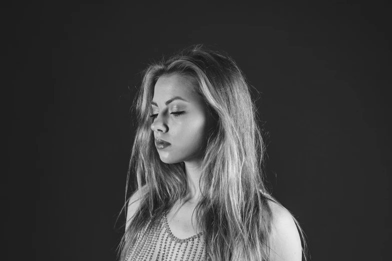 woman standing up in dark room wearing a tank top