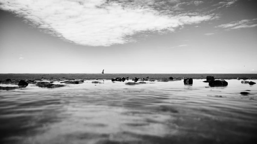 two people standing in the ocean with some water