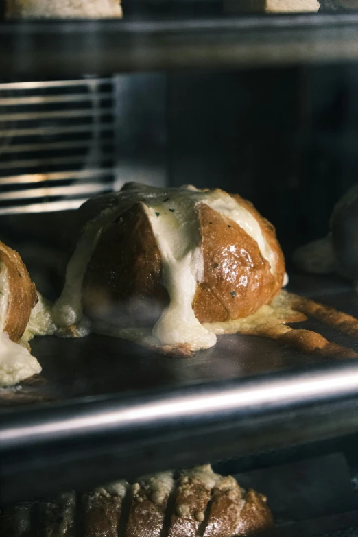 breads being made in an oven with melted cheese