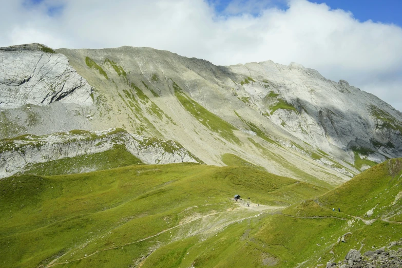 a mountain with some grass and mountains