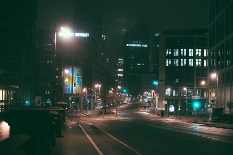 city street at night with lights illuminating street signs