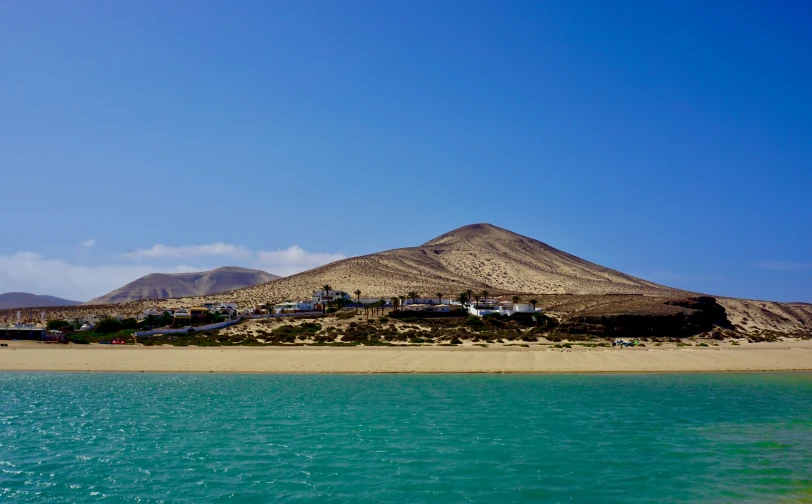 there is a hill and water on the sand