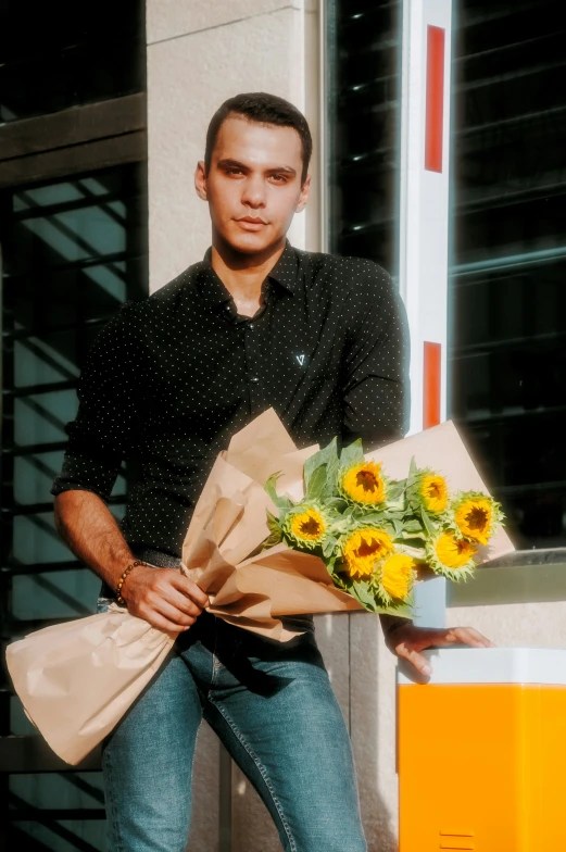 a man is holding a bunch of flowers