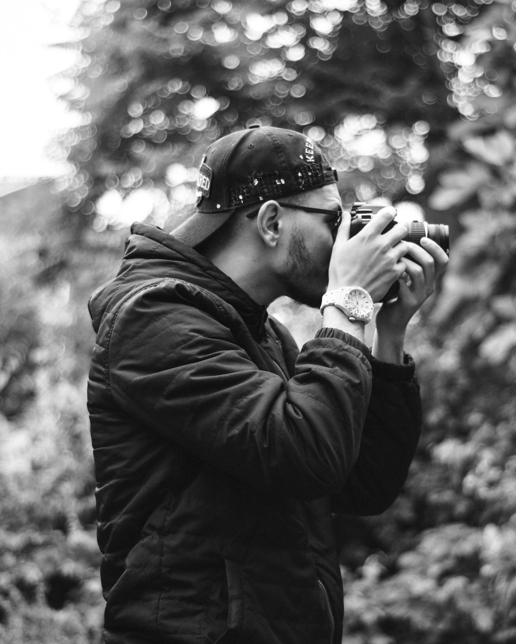 man standing in black and white taking pictures with camera
