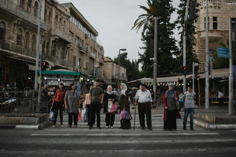 people crossing the street in front of a stop light