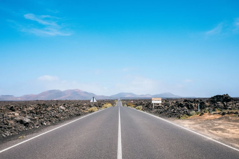 an empty deserted road is seen in the desert