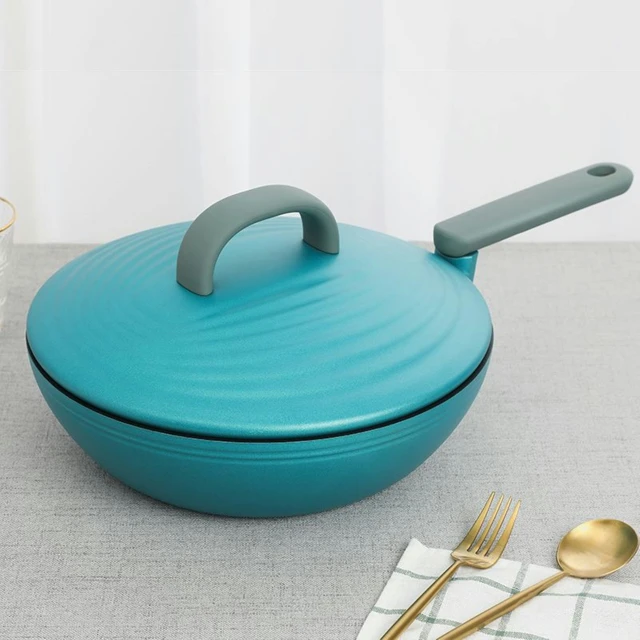 a blue bowl with a large round handle next to golden utensils