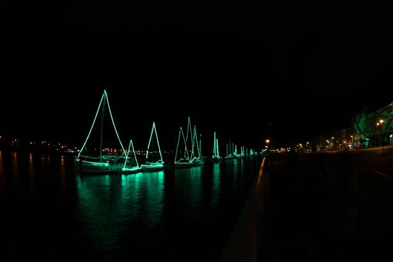 an illuminated sailboat sailing down a river at night
