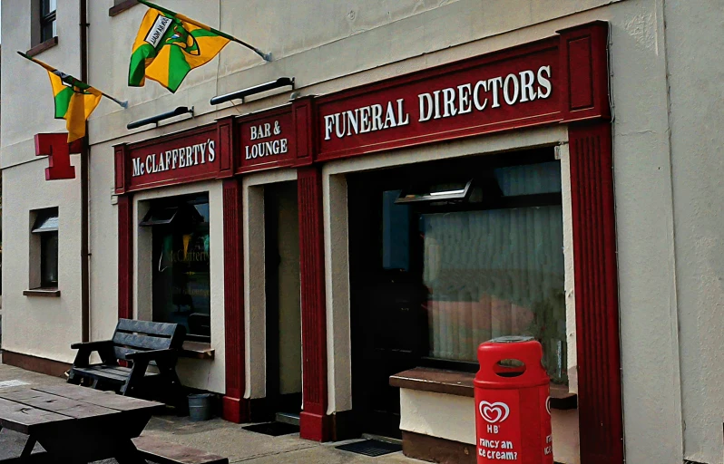 two benches are set outside of the exterior of a liquor store